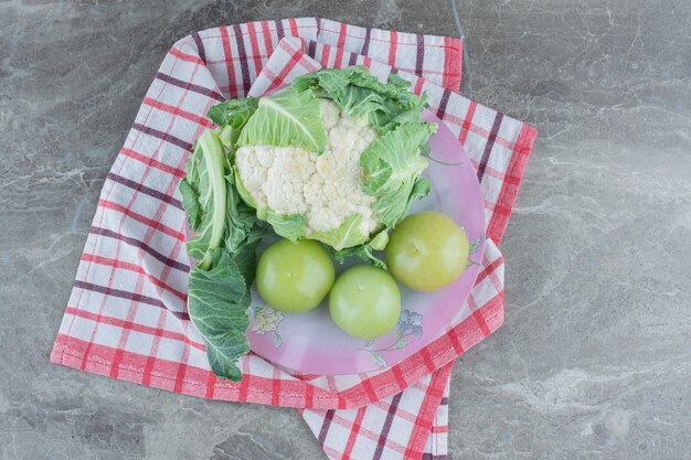 Coliflor fresca con tomates verdes inmaduros.