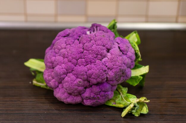 Coliflor morada sobre una mesa de madera en la cocina