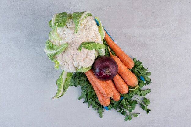 Coliflor, zanahoria y cebolla en placa azul. Foto de alta calidad