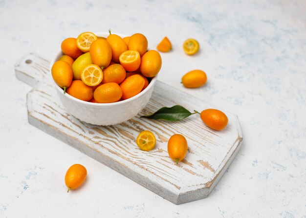 Colocación plana de kumquats sobre una superficie de concreto