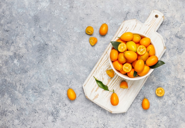 Colocación plana de kumquats sobre una superficie de concreto