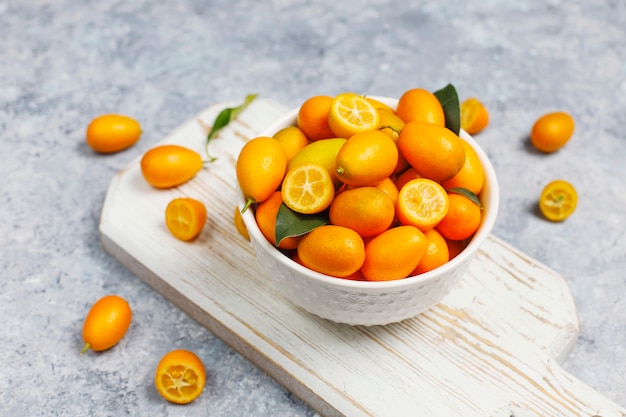 Colocación plana de kumquats sobre una superficie de concreto