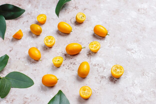 Colocación plana de kumquats sobre una superficie de concreto