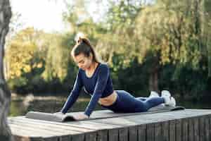 Foto gratuita colocar joven ejercicio sobre colchoneta en el parque