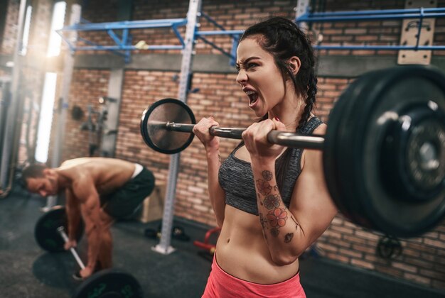 Colocar pareja levantando pesas en el gimnasio