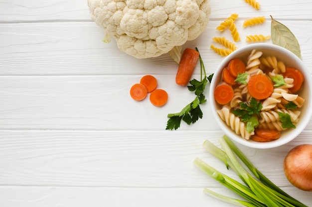 Coloque el brócoli fusilli y las zanahorias en un tazón con coliflor y copie el espacio