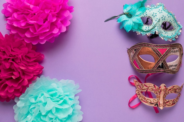 Foto gratuita coloridas flores de papel con máscaras de carnaval