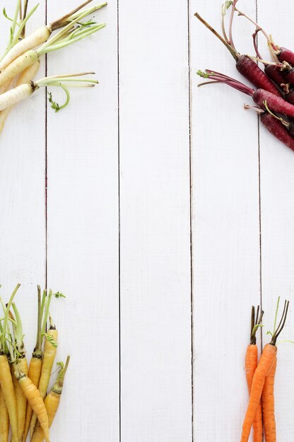 Coloridas zanahorias en el fondo de la mesa de madera