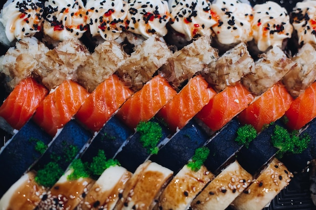 Colorido y delicioso juego de sushi en el plato que incluye diferentes ingredientes pescado caviar arroz pepino salmón salsa de soja wasabi semillas de sésamo Una presentación interesante