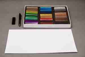Foto gratuita colorido pastel, bolígrafo, papel sobre mesa gris