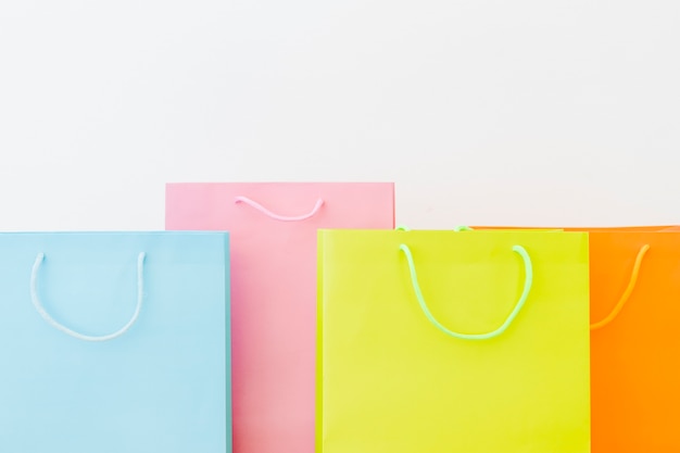 Foto gratuita coloridos bolsos de compras en la superficie blanca