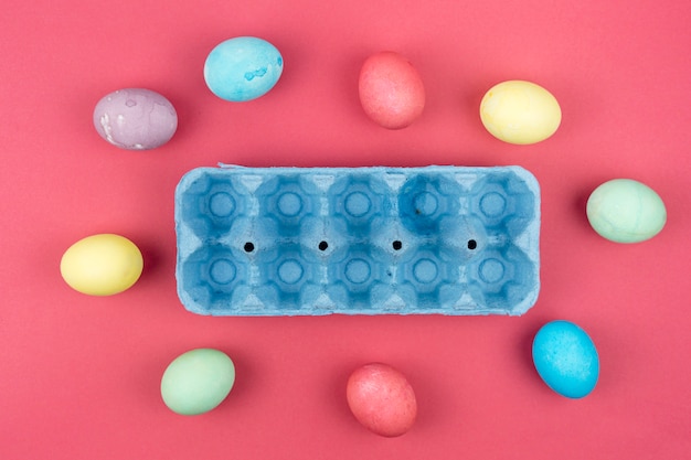 Coloridos huevos de Pascua con caja azul en mesa