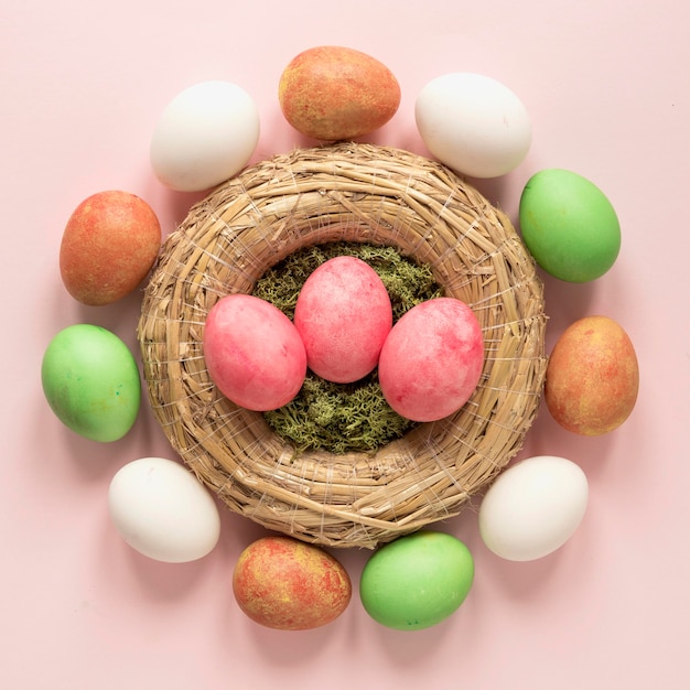 Foto gratuita coloridos huevos de pascua en canasta de heno