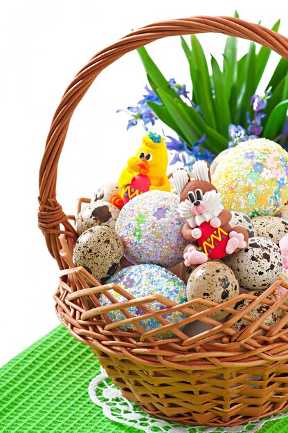 Coloridos huevos de Pascua en una cesta en un blanco