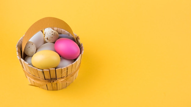 Foto gratuita coloridos huevos de pascua en cesta de madera