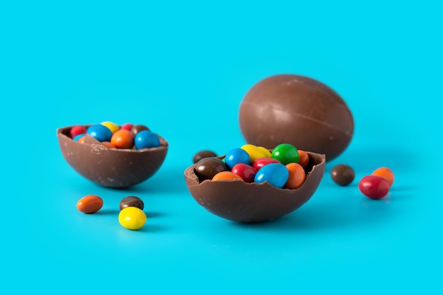 Foto gratuita coloridos huevos de pascua de chocolate en fondo azul