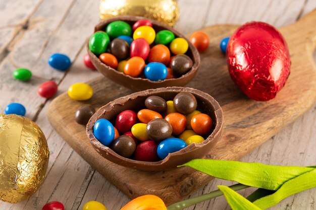 Coloridos huevos de Pascua de chocolate en la mesa de madera