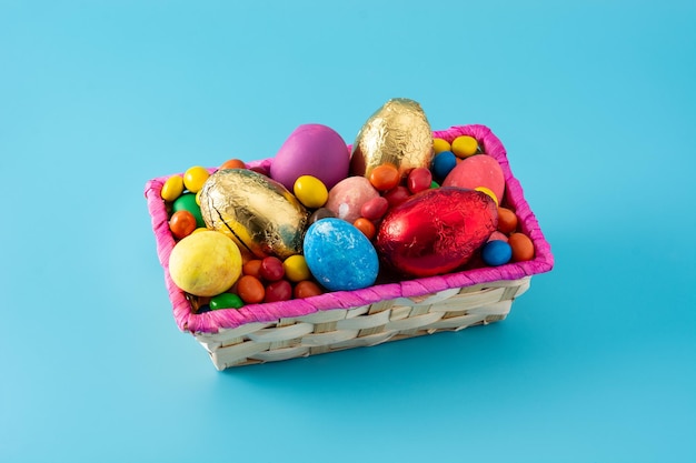 Coloridos huevos de Pascua de chocolate sobre fondo azul.