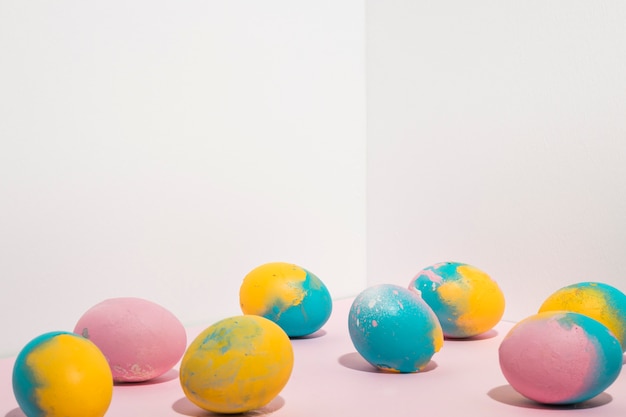 Foto gratuita coloridos huevos de pascua dispersos en mesa de luz