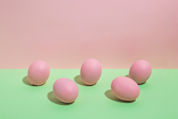 Coloridos huevos de Pascua dispersos en mesa verde
