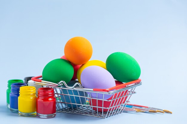 Coloridos huevos de Pascua y orejas de conejo en la mesa