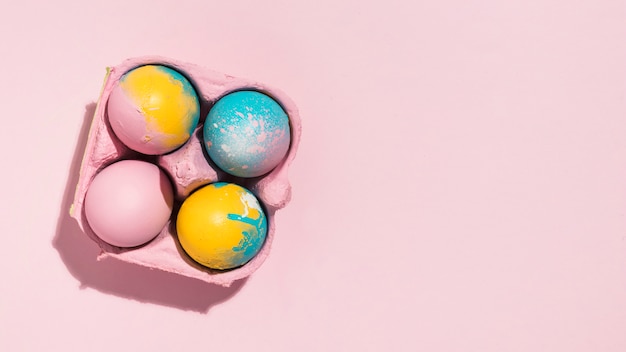 Coloridos huevos de Pascua en rejilla en mesa