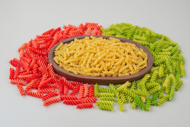 Foto gratuita coloridos macarrones crudos deliciosos en placa