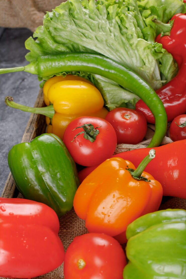 Foto gratuito coloridos pimientos con vegetación. vista superior.