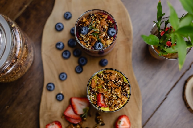 Coloridos postres dulces de desayuno saludable algunos diferentes budines de chia en frascos de vidrio sobre la mesa de madera en la cocina de casa.