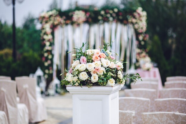 Columna con el bouquet rico de rosas se coloca fuera