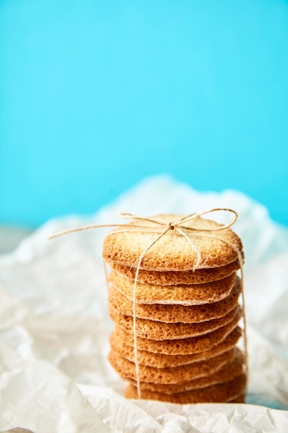 Foto gratuita columna de sabrosas galletas atadas con cuerda para regalo sobre fondo turquesa