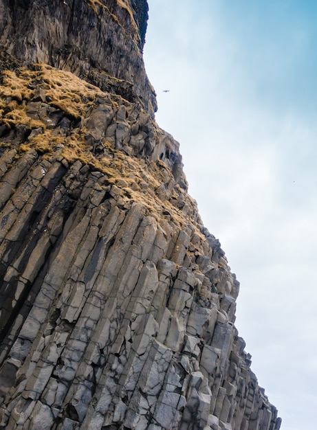 Foto gratuita columnas de basalto gris cerca de la playa de reynisdrangar, islandia.