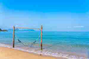 Foto gratuita columpio de hamaca vacía en la hermosa playa y el mar