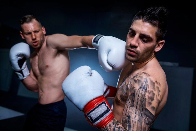 Combate de boxeo en acción entre dos atletas masculinos