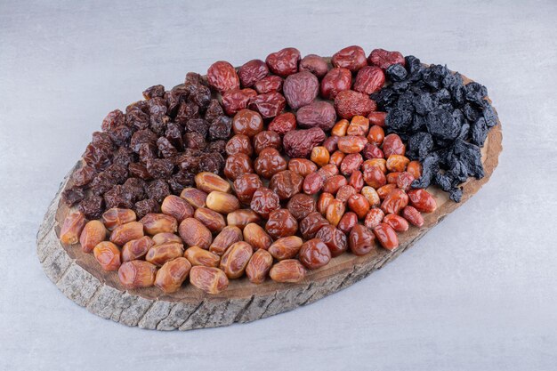 Combinación de frutos secos en un plato de madera. Foto de alta calidad