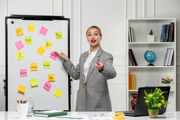 Foto gratuita comercialización de una joven y linda mujer de negocios con un blazer gris en la oficina que tiene una conferencia