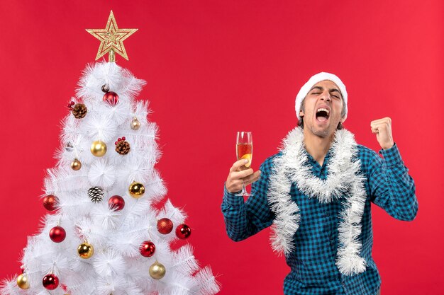 Cómic emocional confiado joven con sombrero de santa claus en una camisa azul a rayas