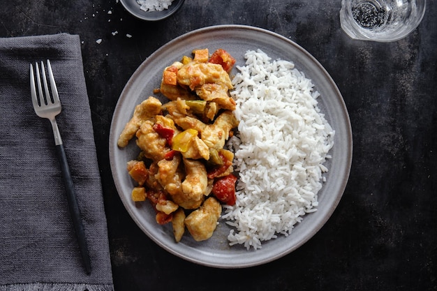 Comida asiática pollo frito con salsa y arroz servido en plato