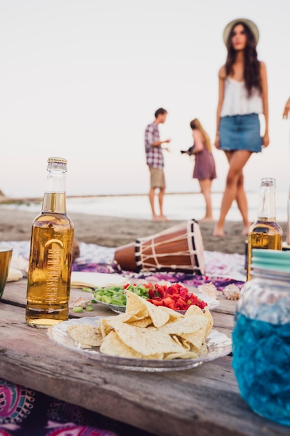 Comida y bebida en placa de madera en la playa