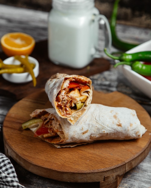 Comida callejera árabe shaurma en lavash en un plato de madera.