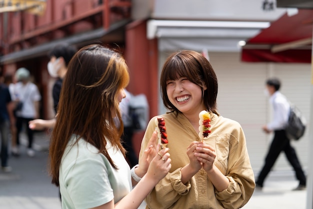 Foto gratuita comida callejera de mujeres sonrientes de tiro medio