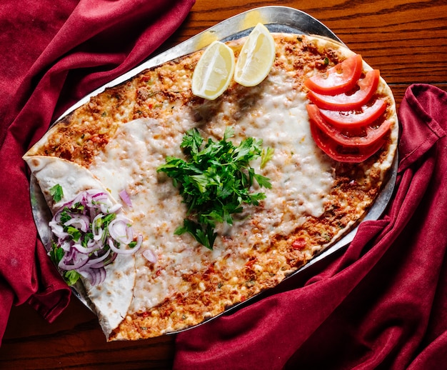 Foto gratuita comida callejera turca lahmacun con tomate, limón, perejil y cebolla.