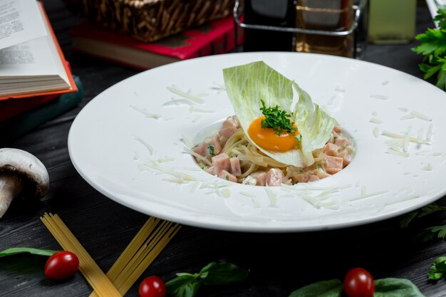 Comida china, fideos con yema de huevo en hoja de ensalada