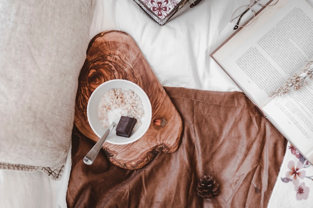 Foto gratuita comida de desayuno cerca de un libro en la cama