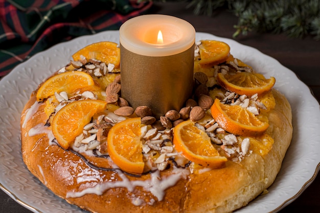 Comida del día de la epifanía con rodajas de naranjas con vela encendida