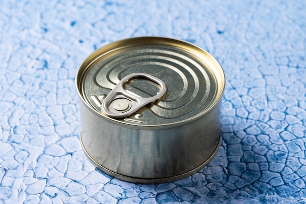 Foto gratuita comida enlatada en lata de metal sobre fondo azul.