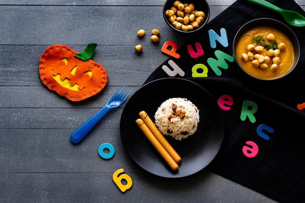 Comida de fiesta de Halloween para niños con risotto de calabaza y salchichas, papel tapiz de fondo