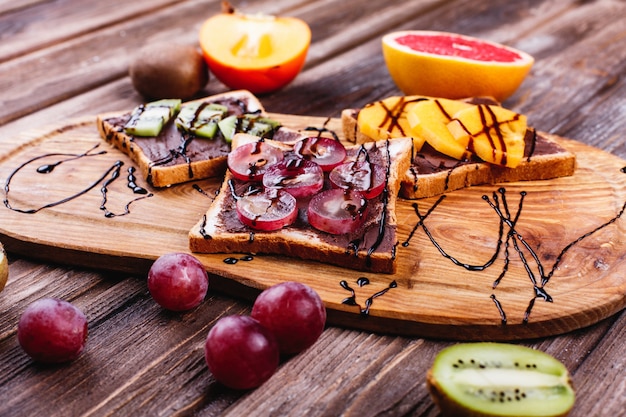 Foto gratuita comida fresca, sabrosa y saludable. ideas para el almuerzo o el desayuno. pan con mantequilla de chocolate, uva.