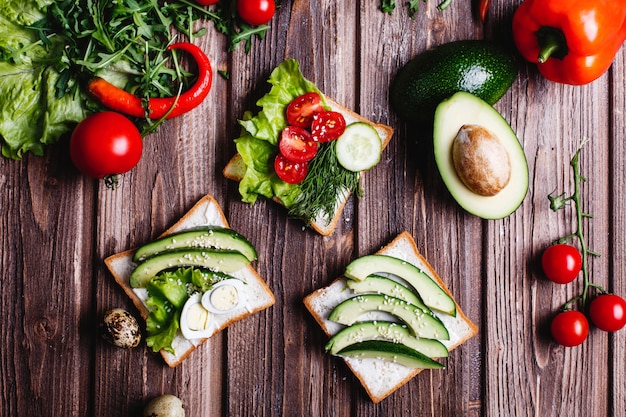 Comida fresca y saludable. Ideas de desayuno o almuerzo. Pan con queso, aguacate y vegetación.