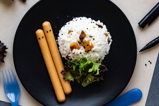 Comida de Halloween espeluznante para niños con arroz de calabaza y salchichas